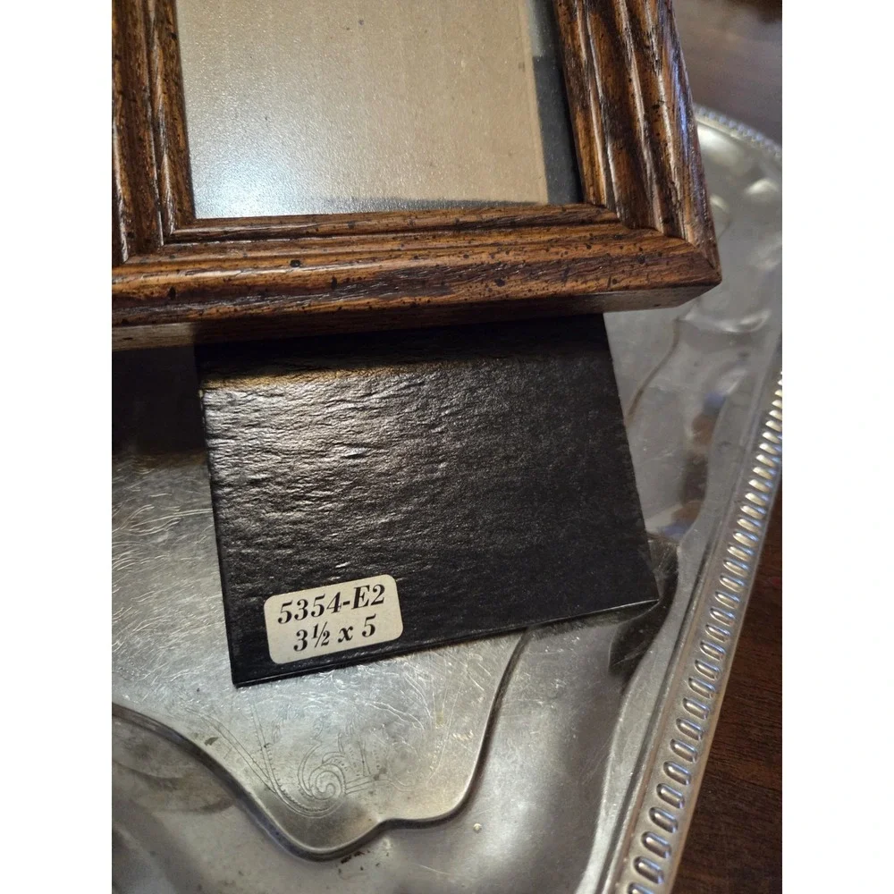 vintage bifold photo frame features a dark brown wood-grain finish and brass...